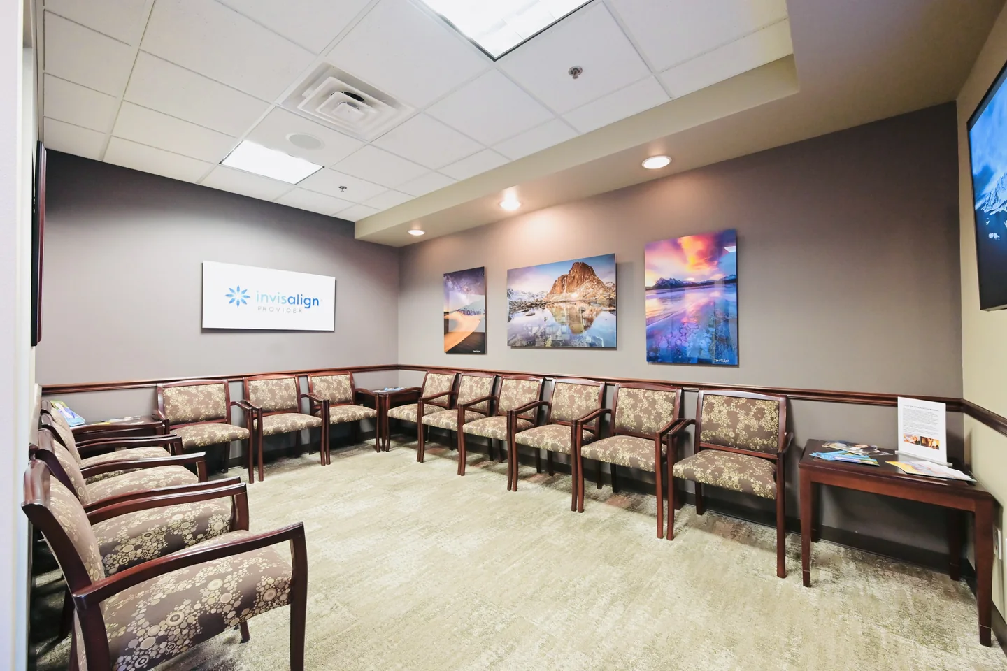 The waiting room at Sandquist Dentistry, with chairs along the walls and landscape photographs